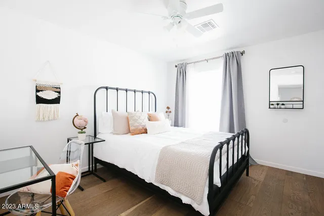 a spacious bedroom with a bed a chandelier and a window