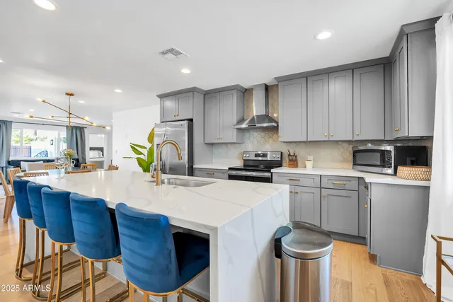 a kitchen with stainless steel appliances granite countertop a sink and a stove