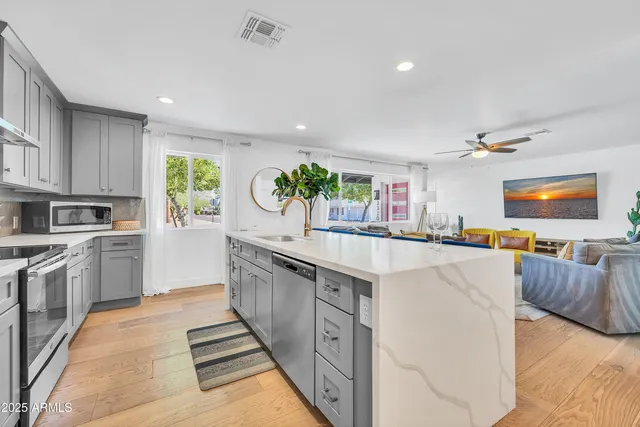 a kitchen with a dining table chairs sink and cabinets