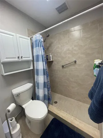 a bathroom with a toilet and a shower