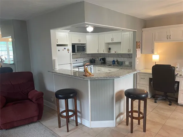 a kitchen with a dining table chairs and refrigerator