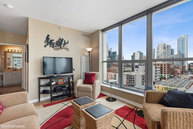 a living room with furniture a flat screen tv and a floor to ceiling window