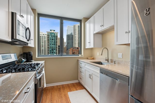 a kitchen with stainless steel appliances granite countertop a sink stove and cabinets