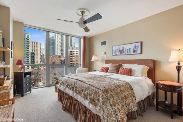 a bedroom with a bed a ceiling fan and a large window