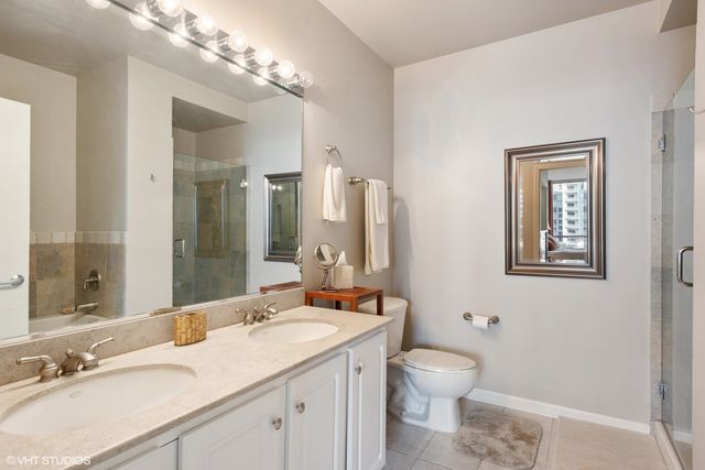 a bathroom with a granite countertop toilet a sink and a mirror