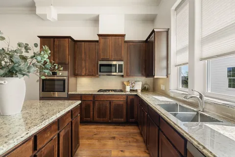 a kitchen with stainless steel appliances granite countertop a sink stove and refrigerator