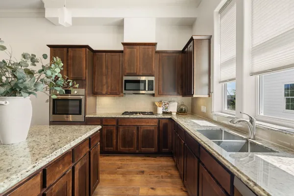 a kitchen with stainless steel appliances granite countertop a sink stove and refrigerator