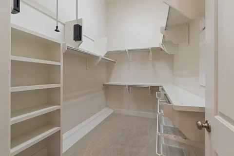 a view of walk in closet with empty racks