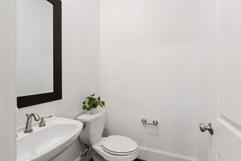 a bathroom with a sink mirror and toilet