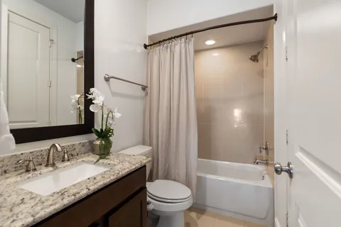 a bathroom with a granite countertop sink toilet and shower