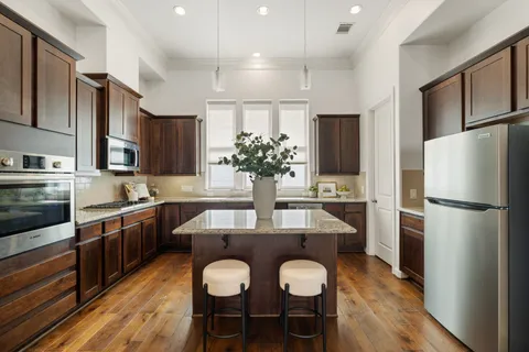 a kitchen with refrigerator a sink and chairs