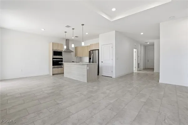 a view of a kitchen with a refrigerator and a stove top oven
