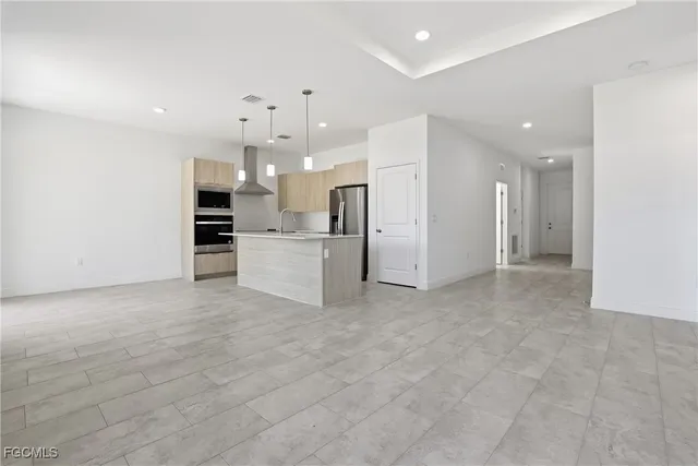 a view of a kitchen with a refrigerator and a stove top oven