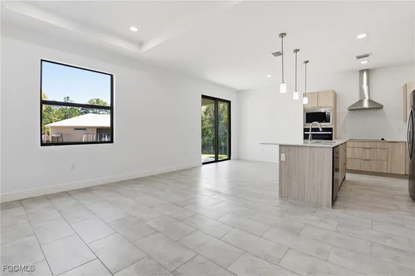 a kitchen with granite countertop a stove a sink a microwave and a refrigerator