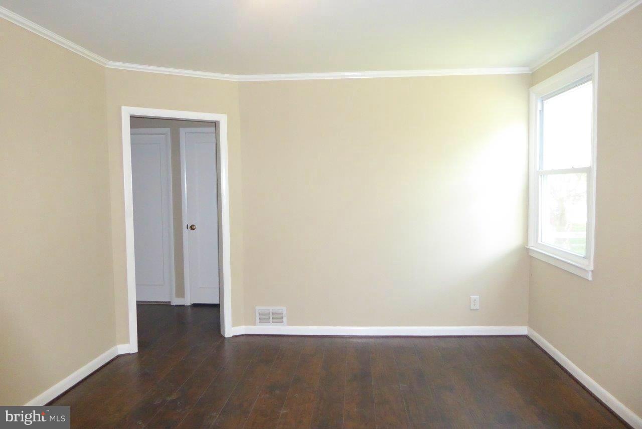 8247 Bullneck Road Baltimore, MD 21222 - Photo 3 of 16 an empty room with wooden floor and windows