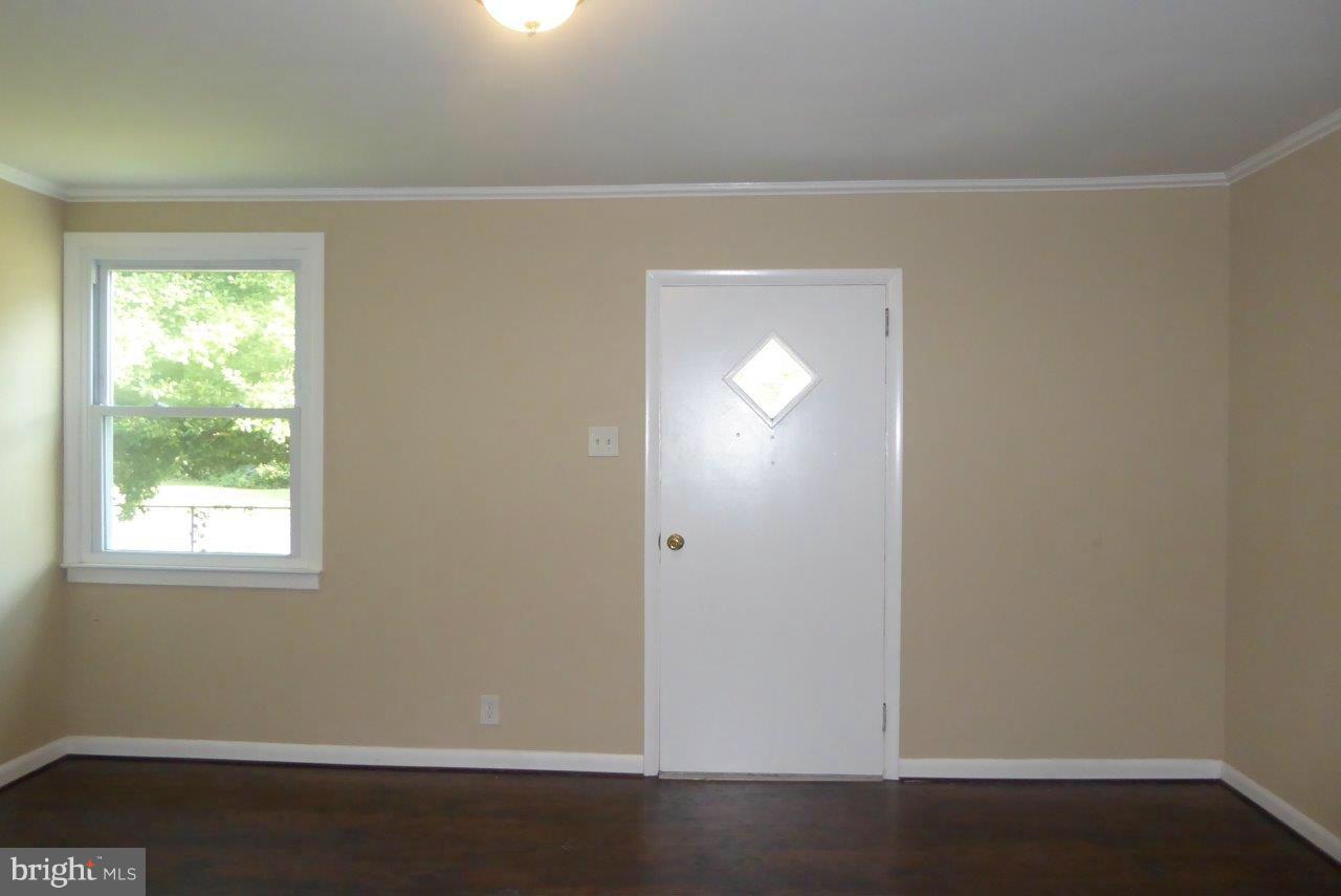8247 Bullneck Road Baltimore, MD 21222 - Photo 4 of 16 an empty room with wooden floor and windows
