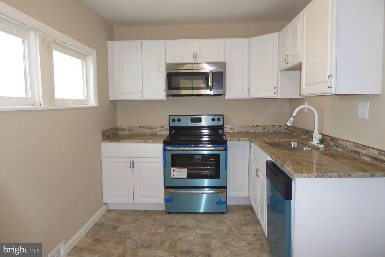 8247 Bullneck Road Baltimore, MD 21222 - Photo 6 of 16 a kitchen with granite countertop a stove and a sink