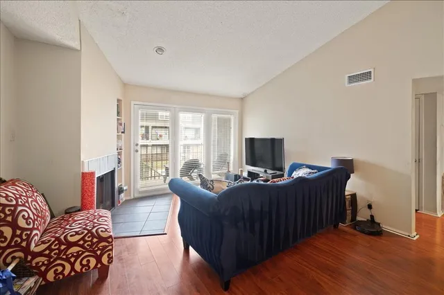 a living room with furniture a flat screen tv and a wooden floor