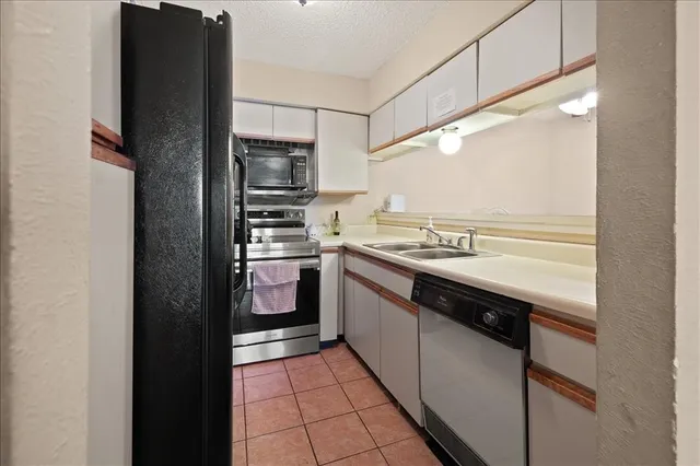 a kitchen with stainless steel appliances granite countertop a refrigerator and a sink