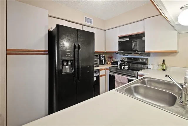 a kitchen with a refrigerator and a sink