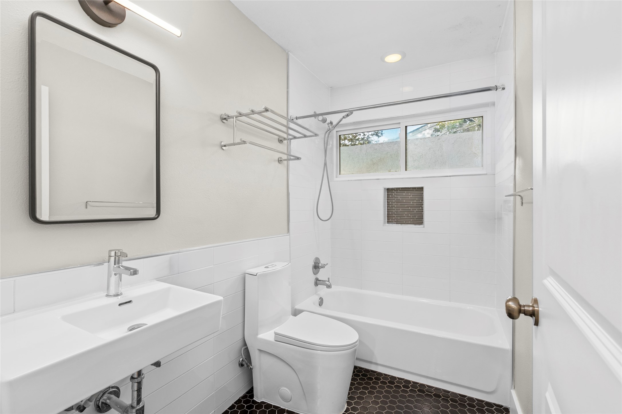 5723 Spellman Road Houston, TX 77096 - Photo 18 of 29 The secondary bathroom has a tub and shower combination, tile flooring, an updated vanity, and a window for natural light.