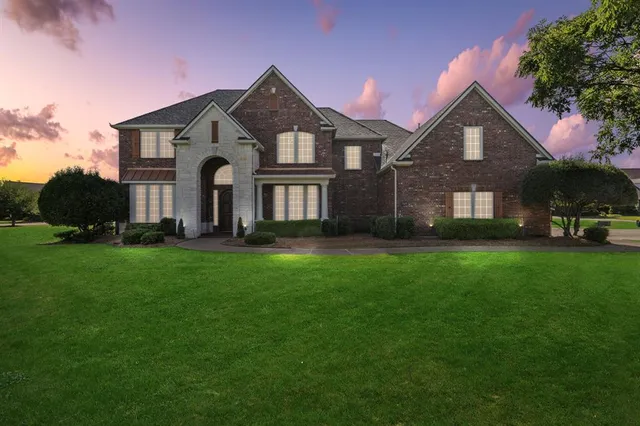 a front view of a house with a yard and green space