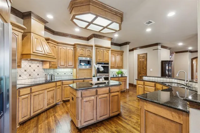 a kitchen with stainless steel appliances granite countertop a sink stove and cabinets