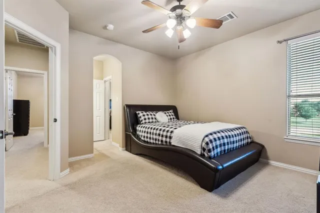 a spacious bedroom with a bed and a chandelier