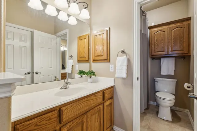 a bathroom with a sink a toilet and large mirror