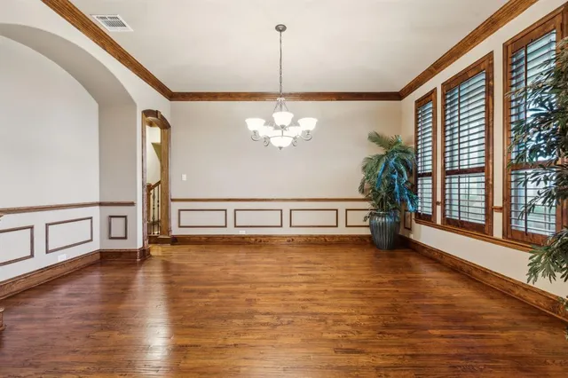 a view of a livingroom with wooden floor and a chandelier