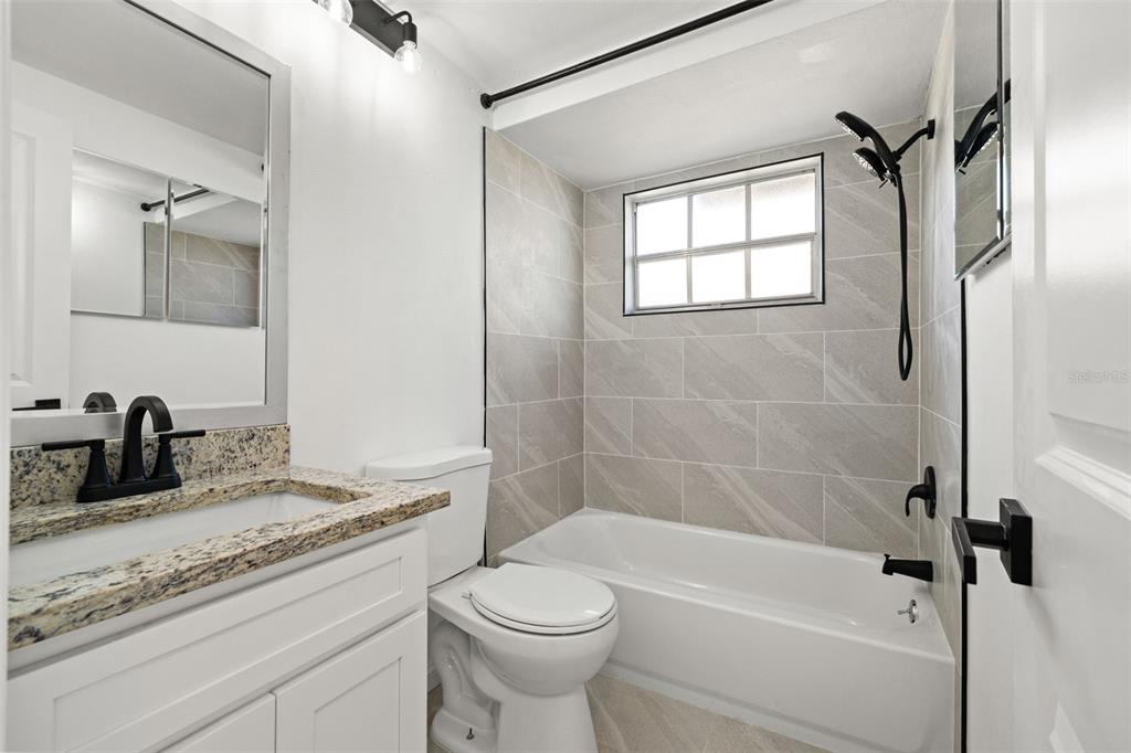 4127 Stratford Drive, Unit 4127 New Port Richey, FL 34652 - Photo 22 of 45 a bathroom with a granite countertop toilet sink and bathtub
