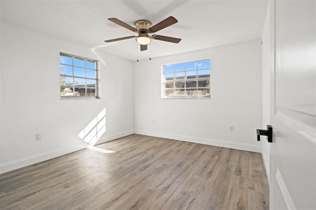4127 Stratford Drive, Unit 4127 New Port Richey, FL 34652 - Photo 24 of 45 an empty room with wooden floor and windows
