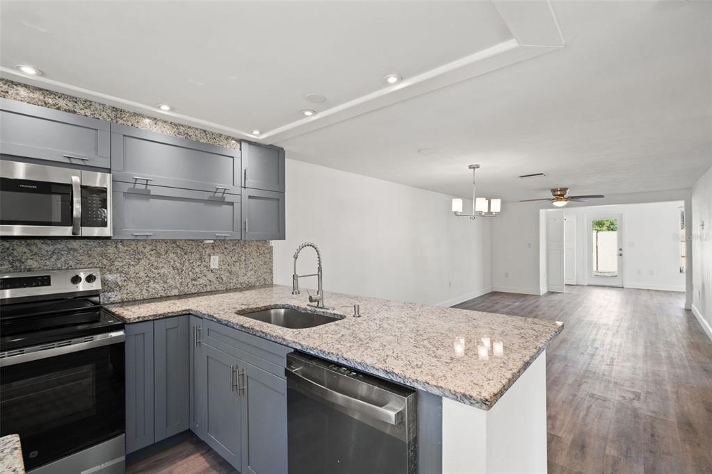 4127 Stratford Drive, Unit 4127 New Port Richey, FL 34652 - Photo 5 of 45 a kitchen with a sink stove and microwave