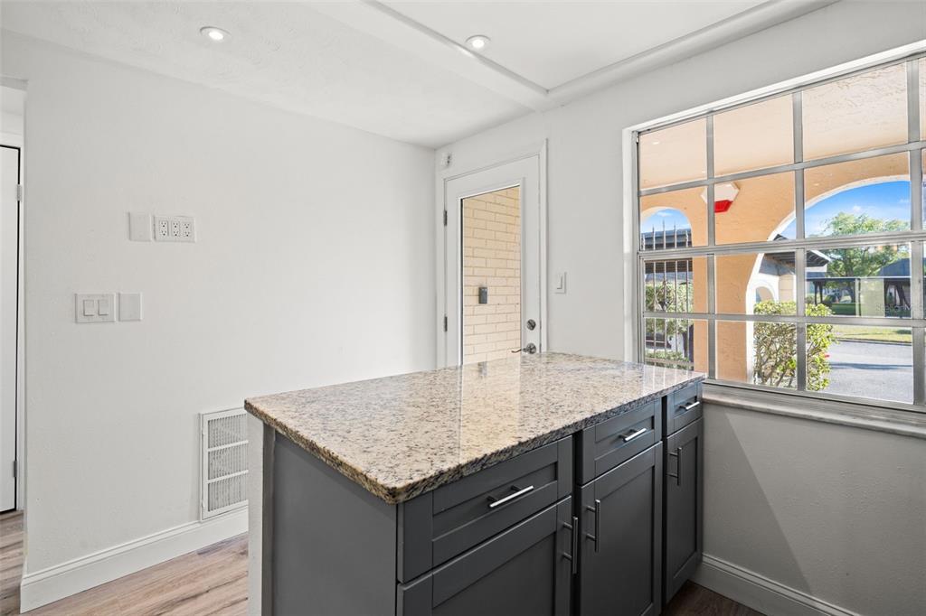 4127 Stratford Drive, Unit 4127 New Port Richey, FL 34652 - Photo 6 of 45 a bathroom with a granite countertop sink and a window
