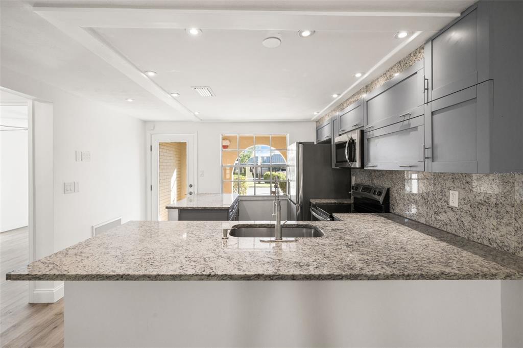 4127 Stratford Drive, Unit 4127 New Port Richey, FL 34652 - Photo 10 of 45 a view of a kitchen with granite countertop a sink and a counter top space