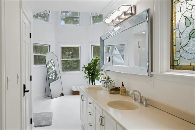 a bathroom with a sink vanity granite tub and a mirror