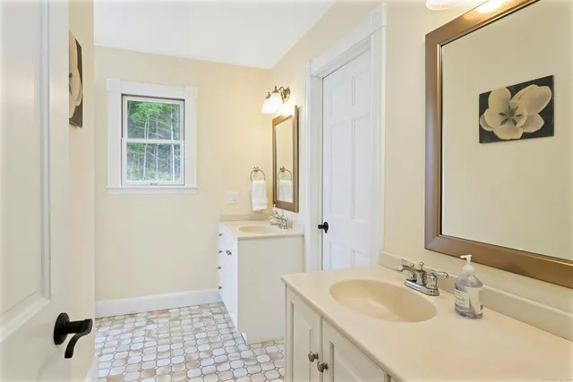 a bathroom with a sink a toilet and a mirror