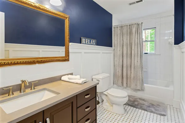 a bathroom with a granite countertop sink a toilet and a shower