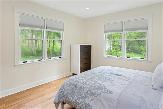 a bed sitting in a bedroom next to a window