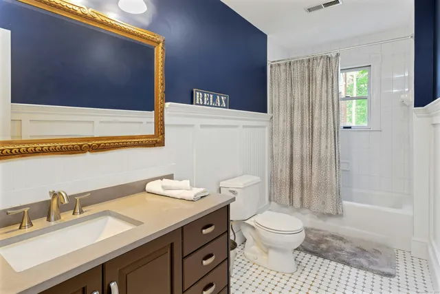 a bathroom with a granite countertop sink a toilet and a shower