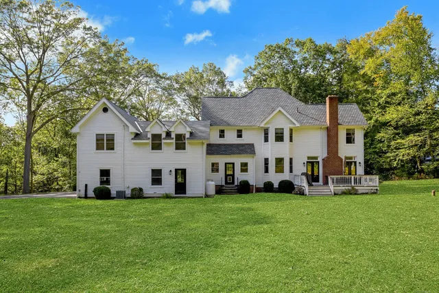 a front view of a house with a yard and trees