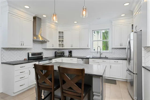 a kitchen with a table chairs refrigerator and cabinets