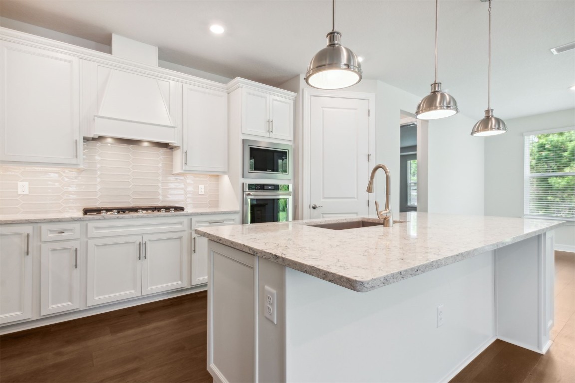 840 Continuum Loop Yulee, FL 32097 - Photo 25 of 64 a kitchen with kitchen island a sink stainless steel appliances and white cabinets