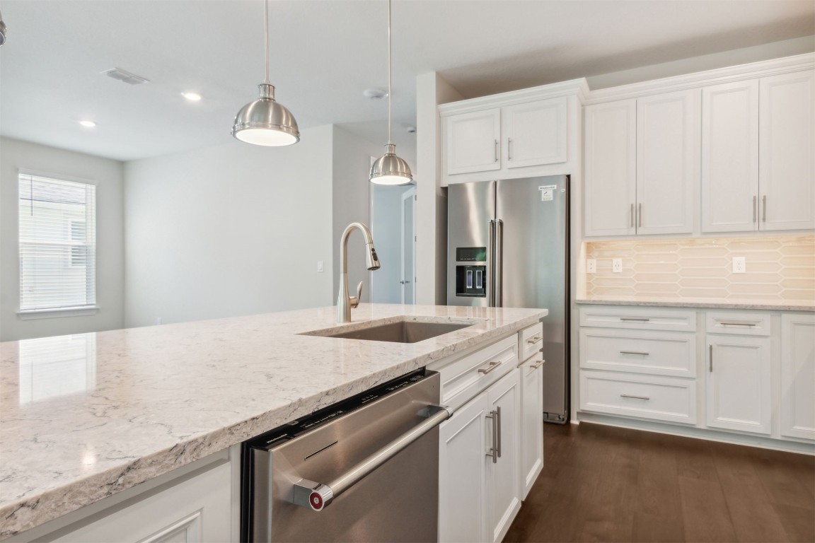 840 Continuum Loop Yulee, FL 32097 - Photo 28 of 64 a kitchen with granite countertop cabinets stainless steel appliances a sink and wooden floor