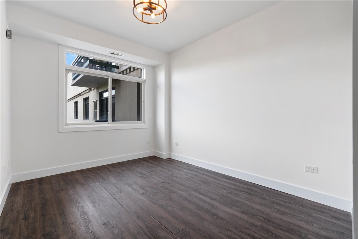 680 North Green Street, Unit 412 Chicago, IL 60642 - Photo 15 of 20 a view of an empty room with wooden floor and a window