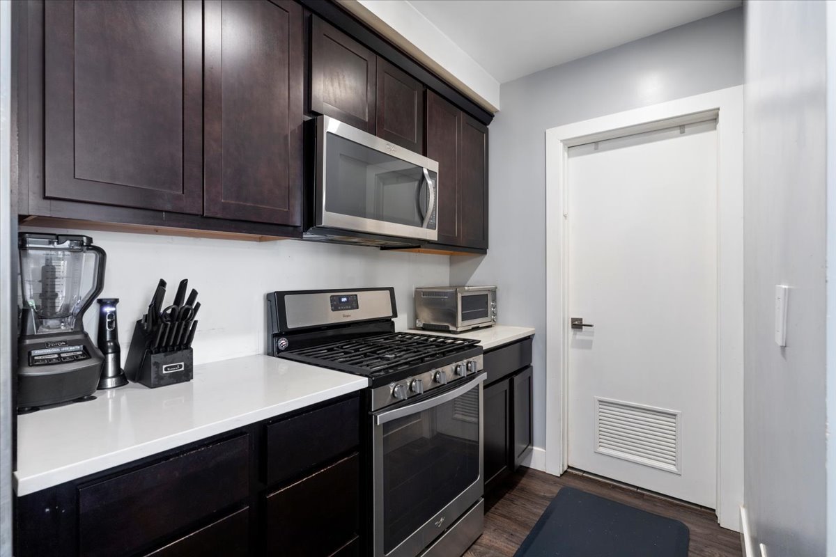 680 North Green Street, Unit 412 Chicago, IL 60642 - Photo 4 of 20 a kitchen with stainless steel appliances a stove a microwave and cabinets