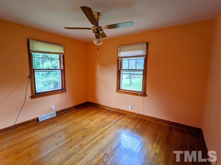 362 Tinker Road Chase City, VA 23924 - Photo 12 of 21 an empty room with wooden floor chandelier fan and windows