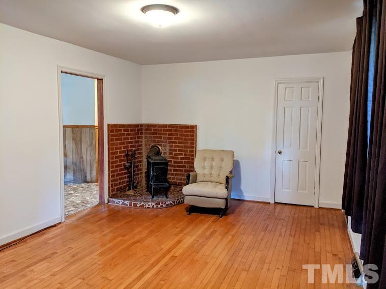 362 Tinker Road Chase City, VA 23924 - Photo 5 of 21 wooden floor in an empty room with a fireplace