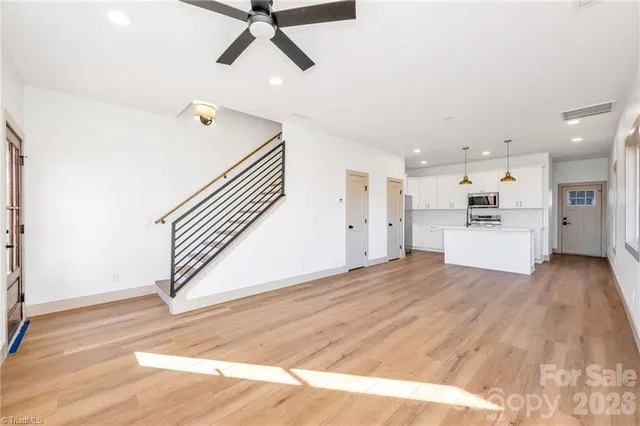 a view of a kitchen with wooden floor and electronic appliances