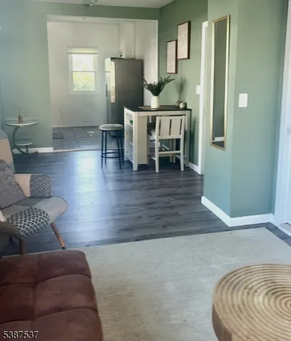 a living room with furniture and a dining table with wooden floor